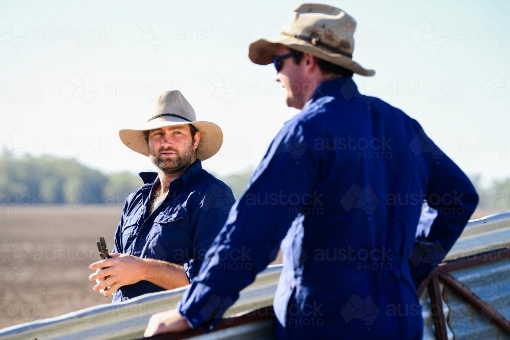 Farmers talk near stockyards during the drought - Australian Stock Image
