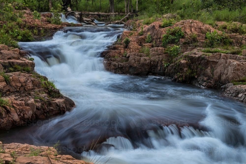 Fast flowing river over rocks - Australian Stock Image