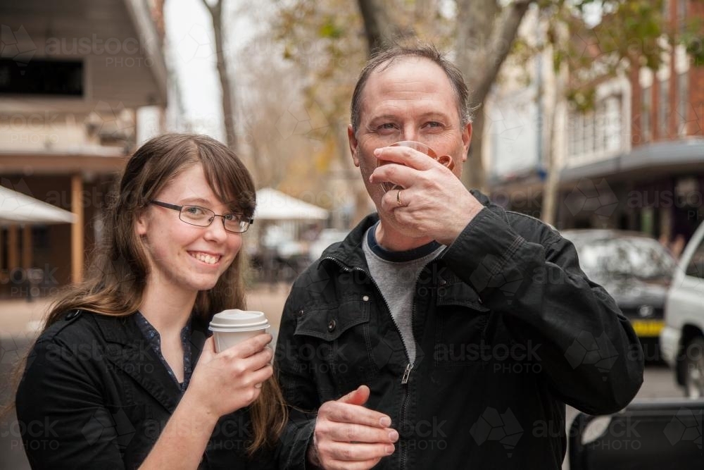 Father and daughter having a coffee together in the street - Australian Stock Image