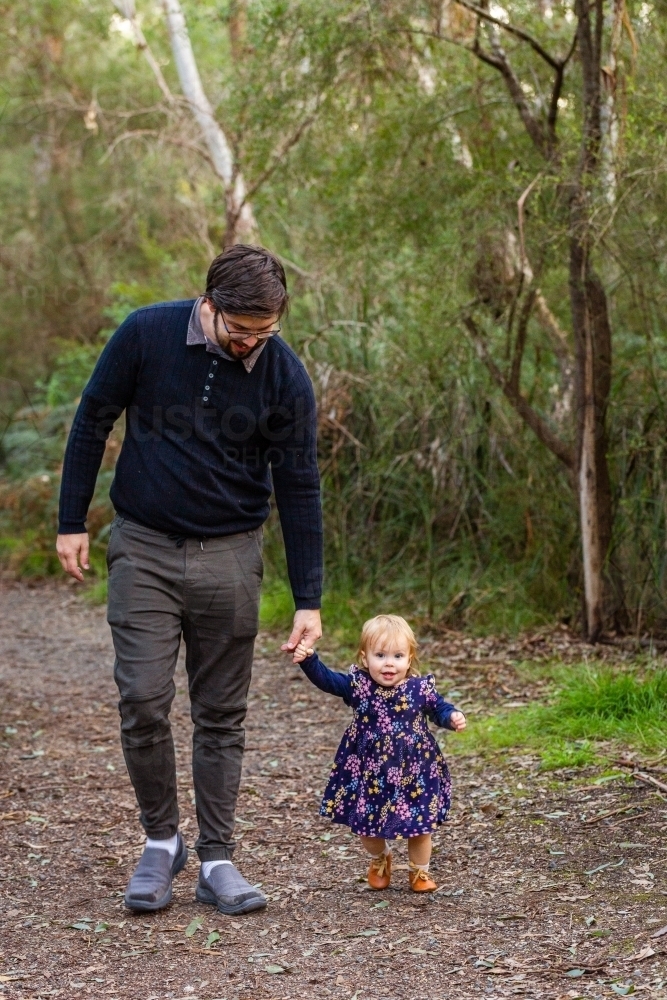 Image of Father and daughter holding hands walking down path in ...