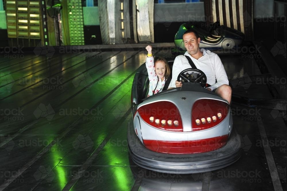 father and daughter on dodgem car at a fun fair - Australian Stock Image