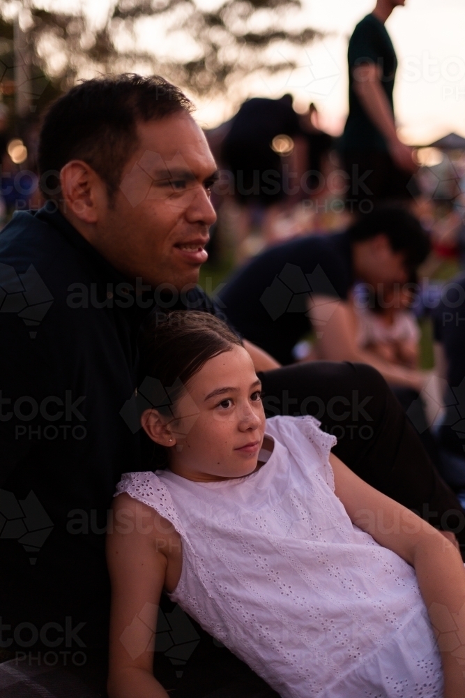 father and daughter relaxing together at carols by candlelight - Australian Stock Image