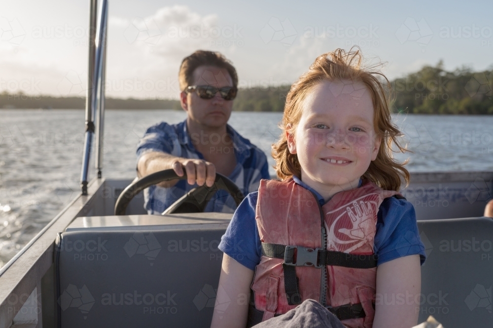 father and daughter steering a boat together - Australian Stock Image