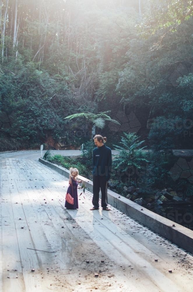 Father and daughter walking along bridge - Australian Stock Image