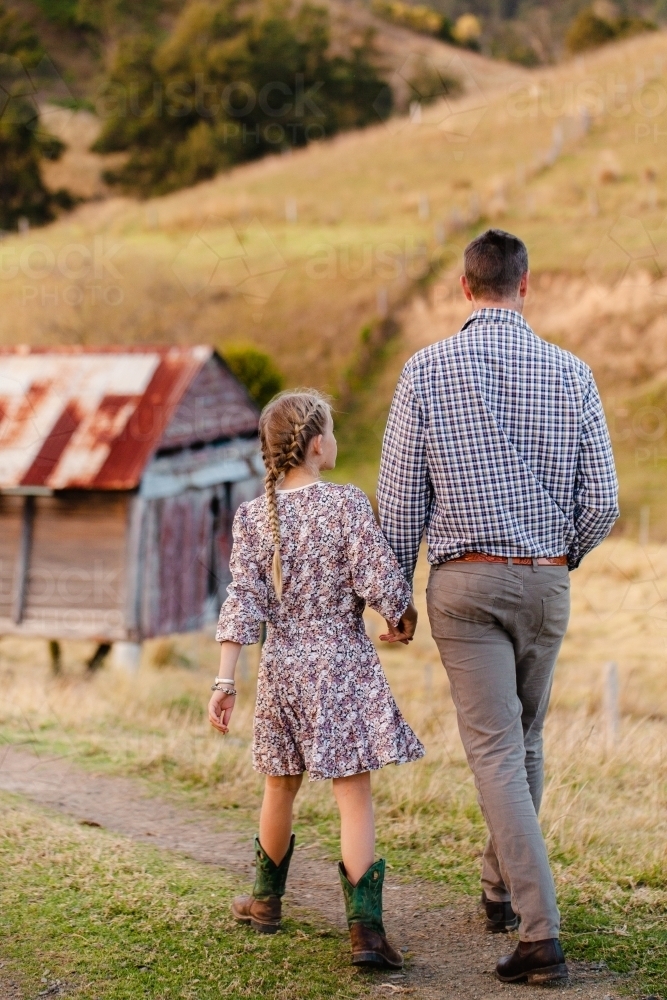 Image of Father and daughter walking down path on country farm ...