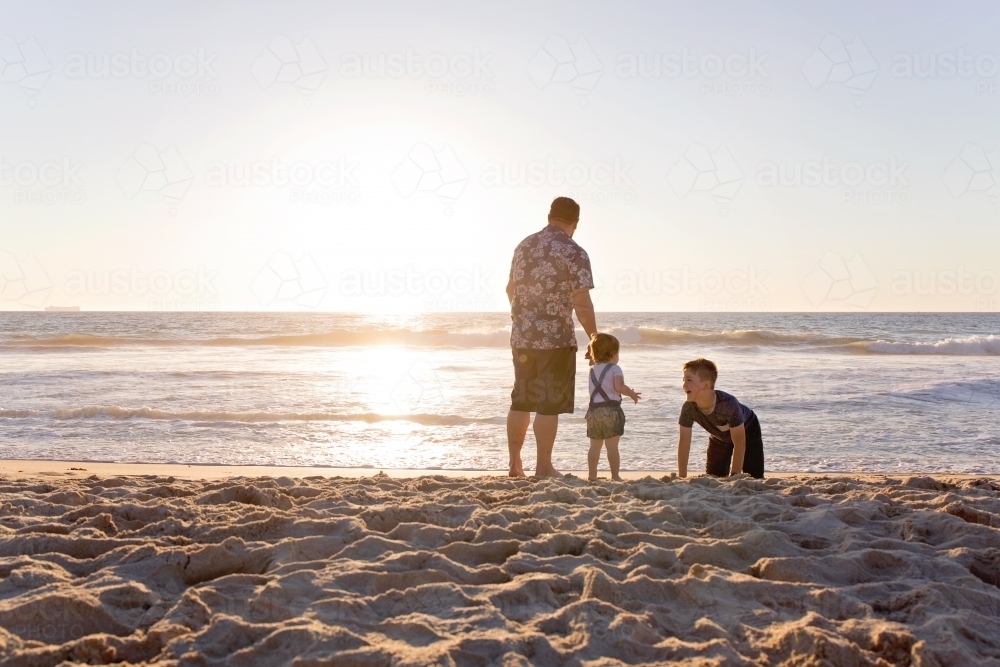 Father And His Two Children At The Beach At Sunset - Australian Stock Image