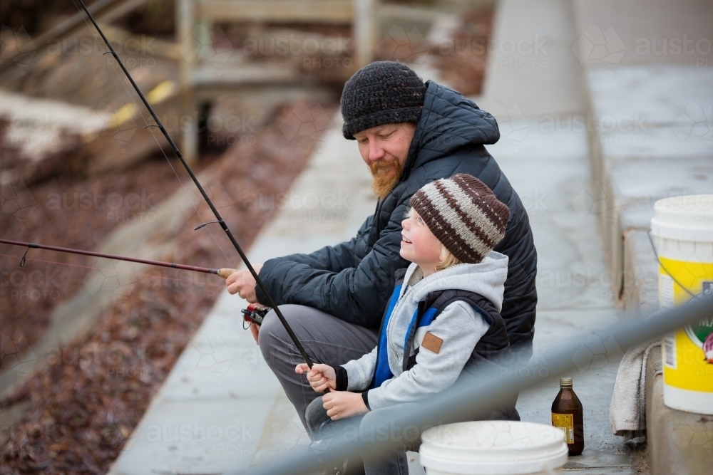 Father and son fishing in winter - Australian Stock Image