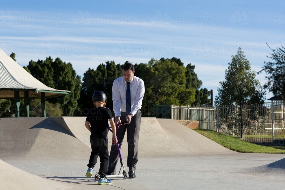 Father and son with scooter at skatepark - Australian Stock Image