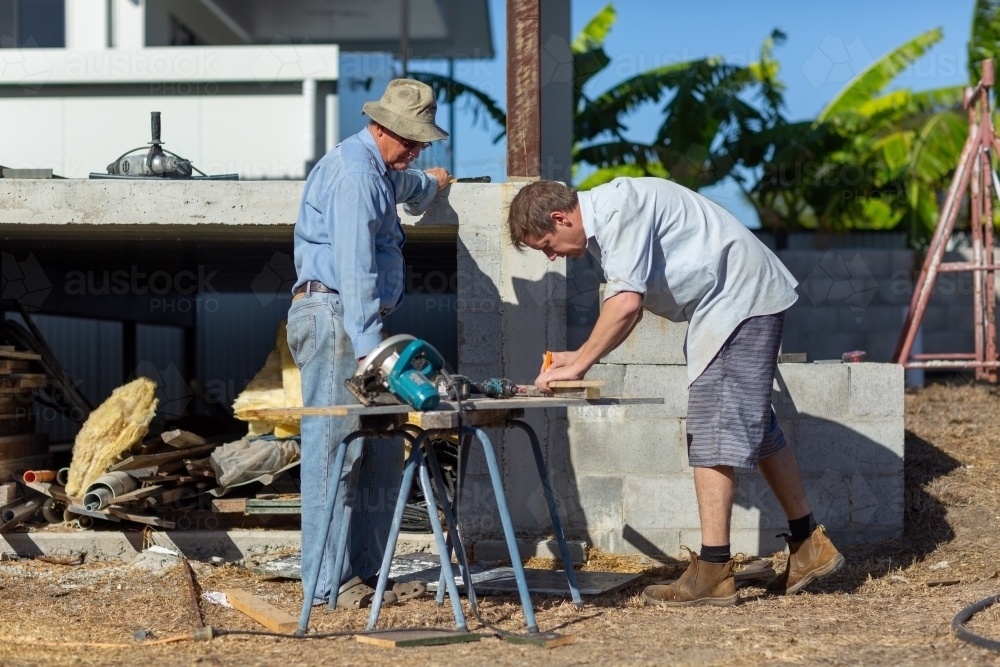 Father and son working together on a building project - Australian Stock Image