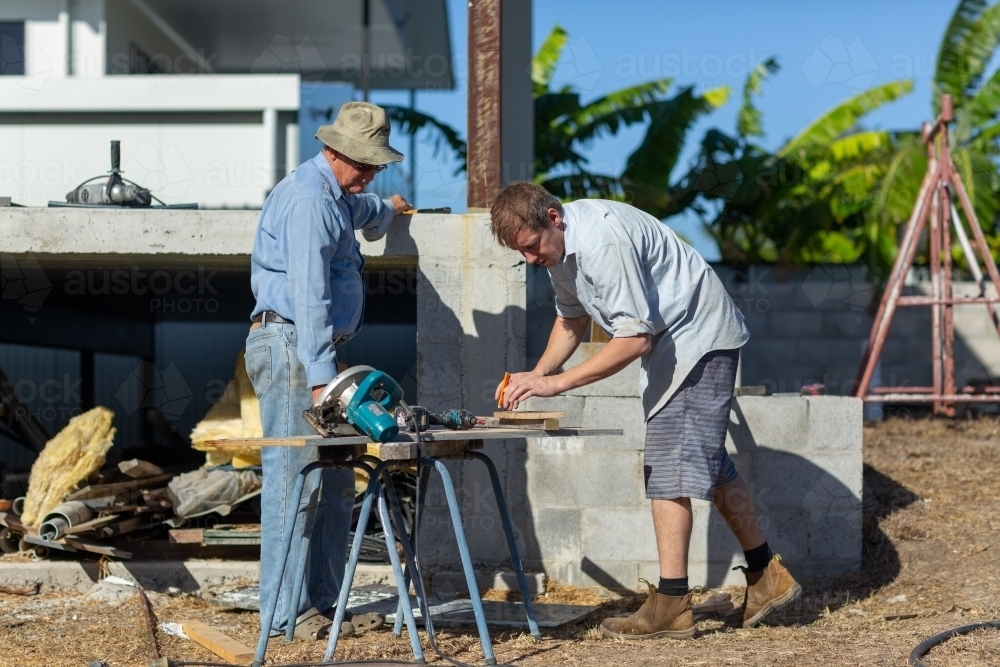 Father and son working together on a building project - Australian Stock Image