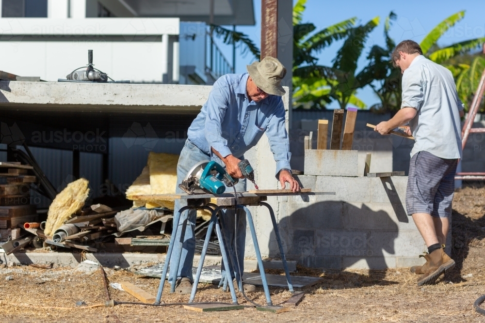 Father and son working together on a building project - Australian Stock Image