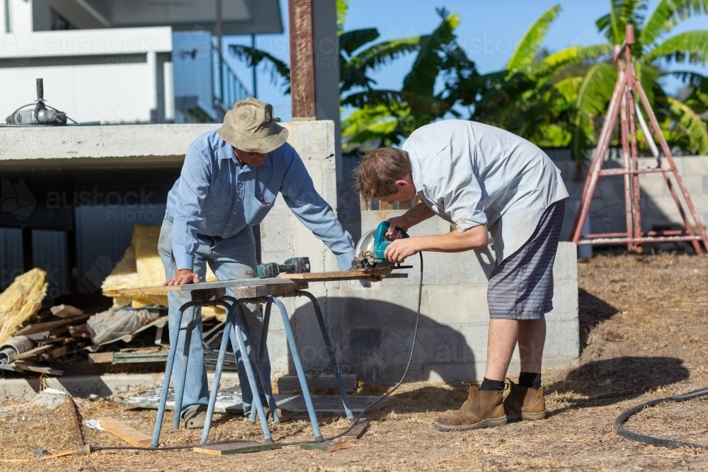 Father and son working together on a building project - Australian Stock Image