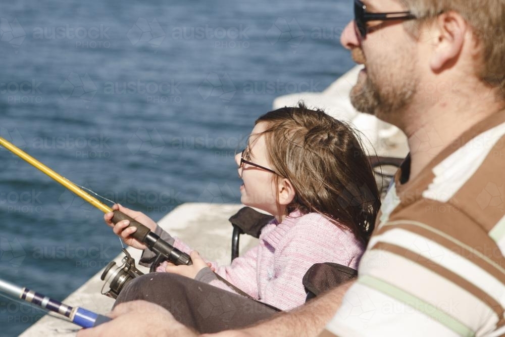 Father and young daughter fishing off wharf - Australian Stock Image