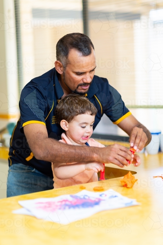 Father doing craft with his young son at the kitchen bench - Australian Stock Image