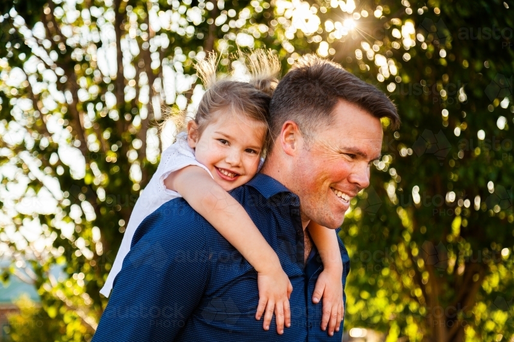Father giving daughter a piggyback - Australian Stock Image