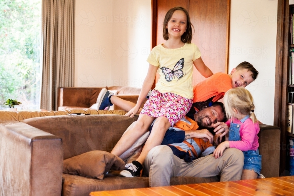 Father home from work playing with his children - Australian Stock Image