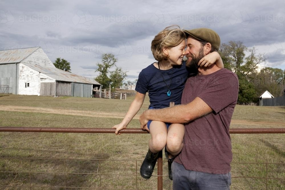 Father hugging daughter outside in paddock - Australian Stock Image