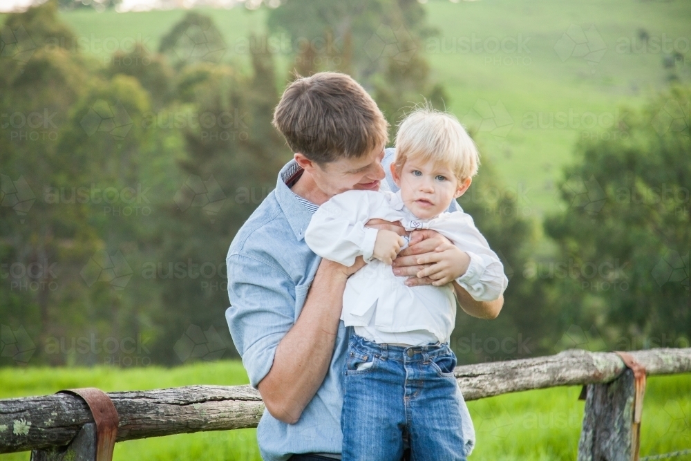 Father lifting up child to kiss him - Australian Stock Image