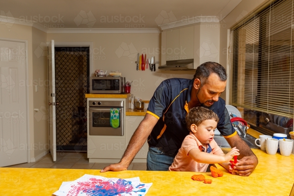 father playing with his young son in the kitchen - Australian Stock Image