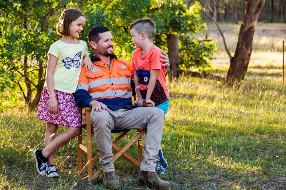 Father relaxing after work with his daughter and son - Australian Stock Image