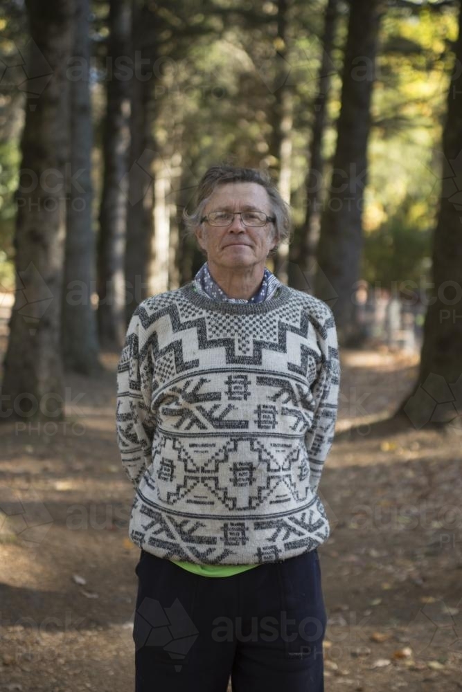 Father standing among large trees in a park - Australian Stock Image