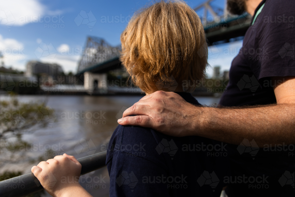 Father with a caring hand resting on his son's shoulder - Australian Stock Image
