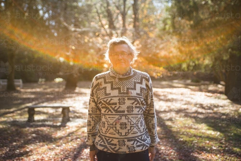 Father with gery hair in park with sun flare - Australian Stock Image