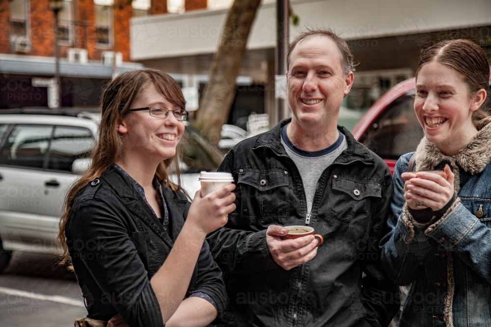Father with his two teenage daughters having coffee in the street - Australian Stock Image