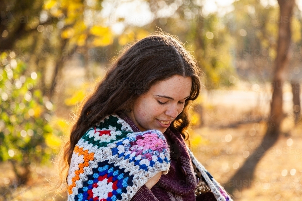 Female adult outside in winter with crochet blanket around shoulders - Australian Stock Image