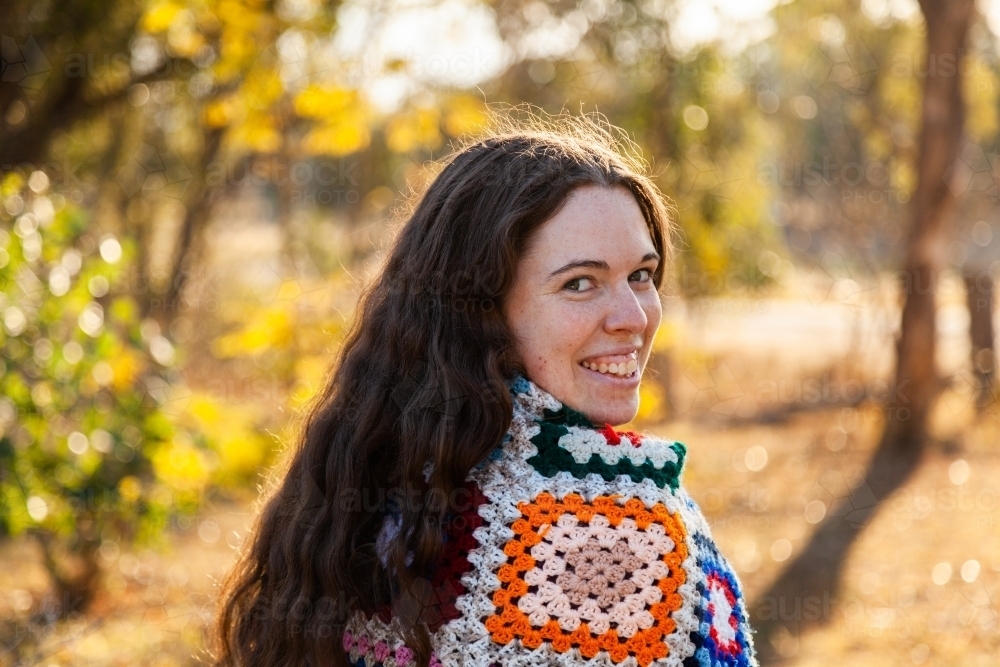 Image of Female adult outside in winter with crochet blanket around