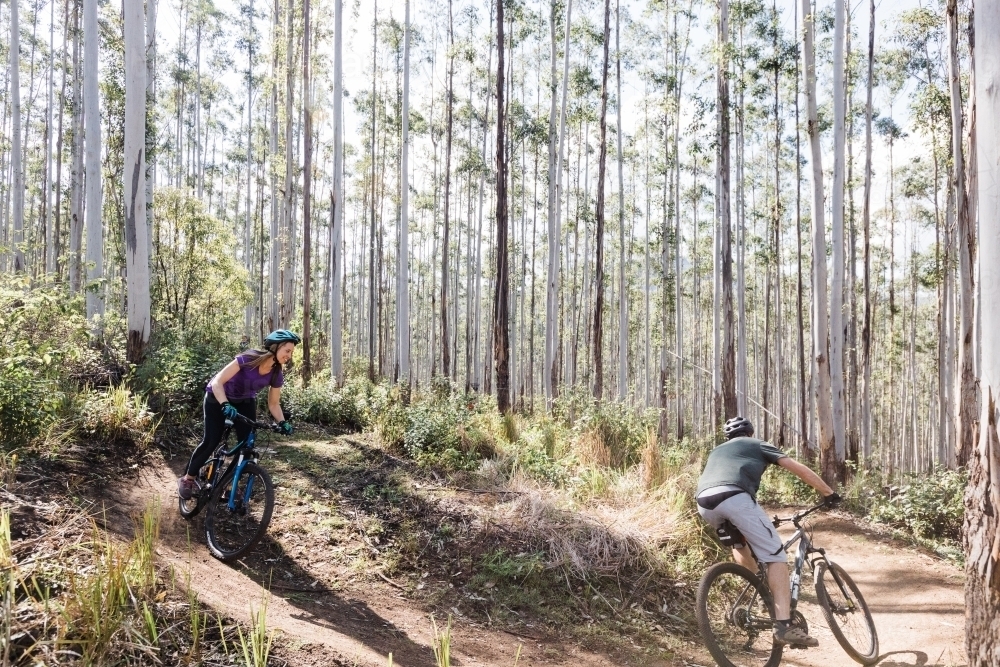Female and male mountain biker on a down hill run - Australian Stock Image