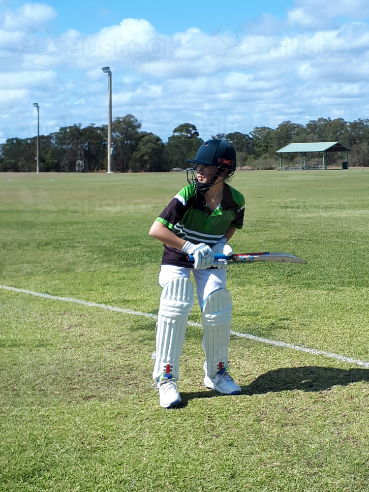 Female Cricket Player on the field waiting for the ball to hit - Australian Stock Image