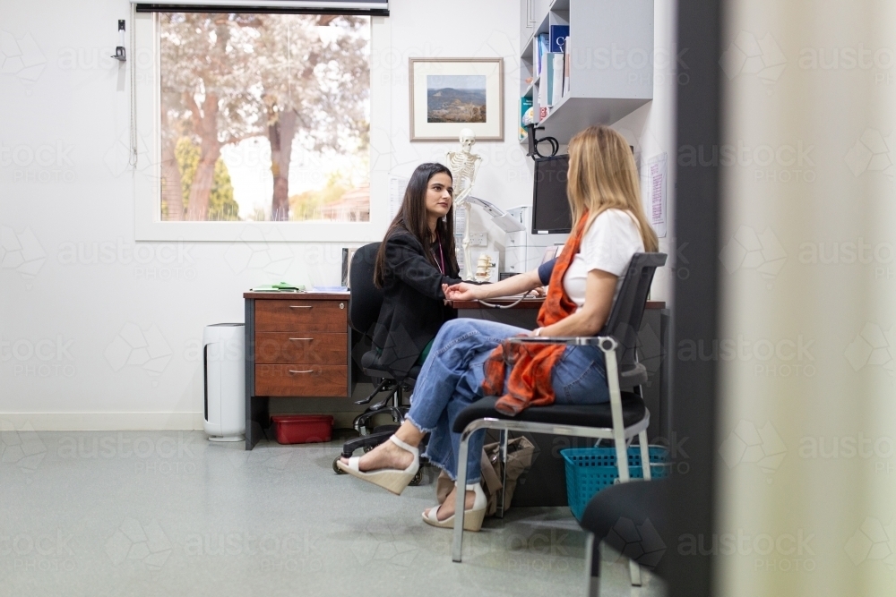 Female doctor checking a patient's blood pressure in the clinic - Australian Stock Image