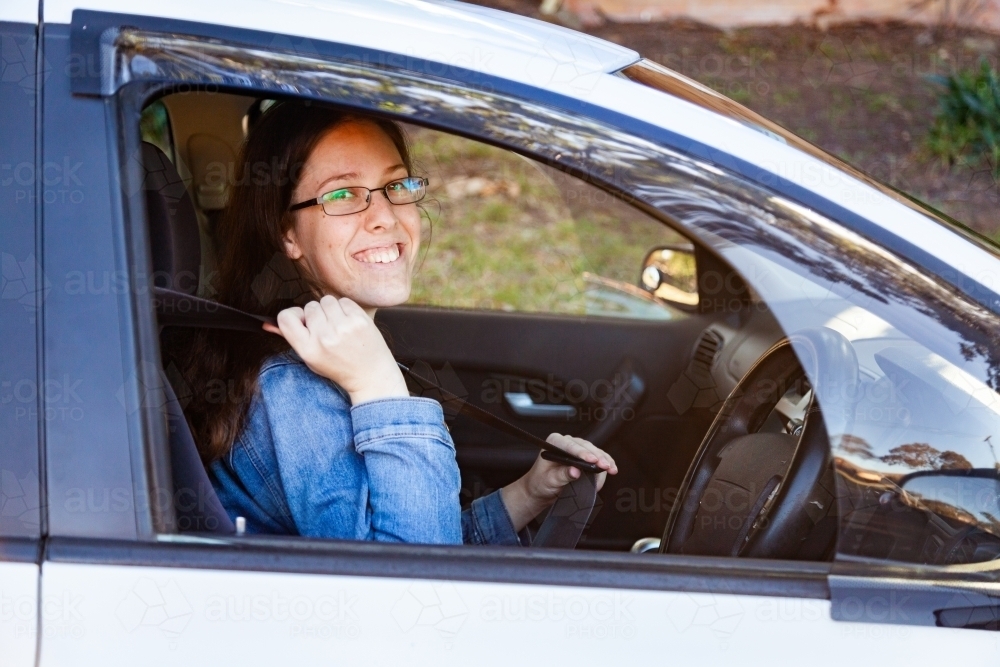Female driver putting on her seat belt - Australian Stock Image