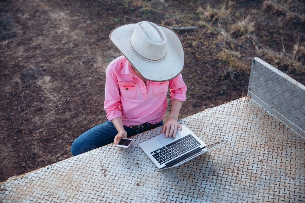 Female farmer using telecommunications device - Australian Stock Image