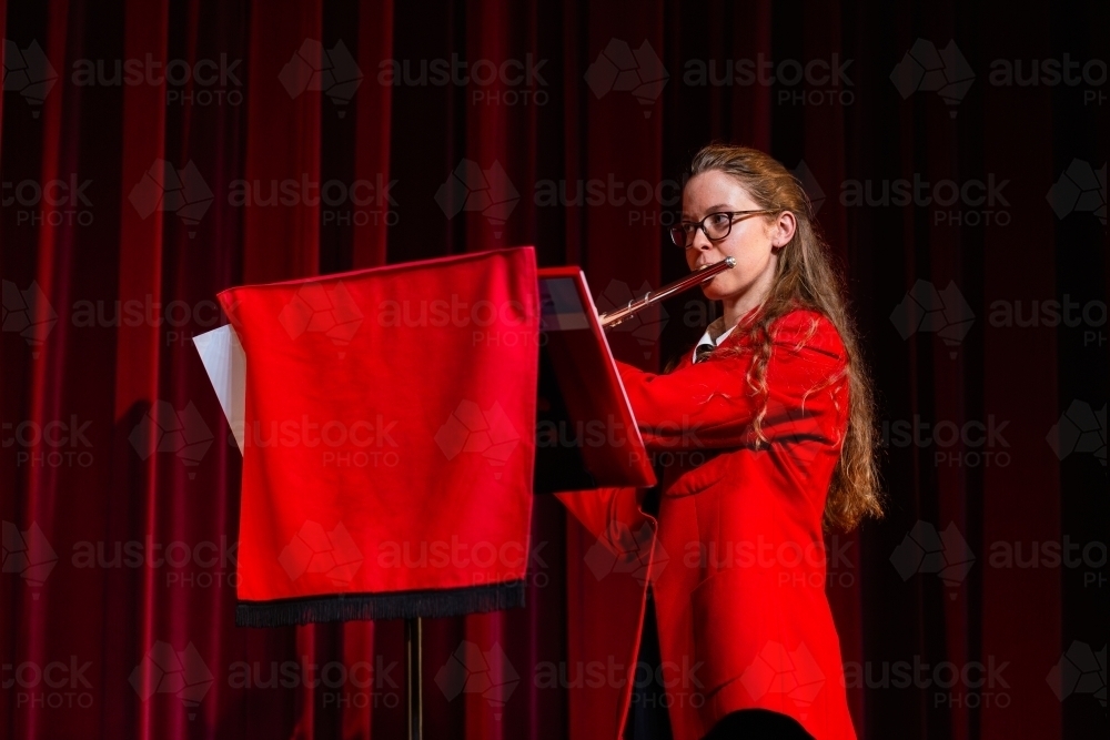 Image of Female flautist playing solo performance on flute at concert