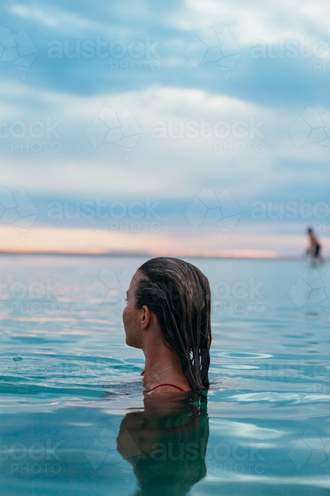 Female in ocean at sunset - Australian Stock Image