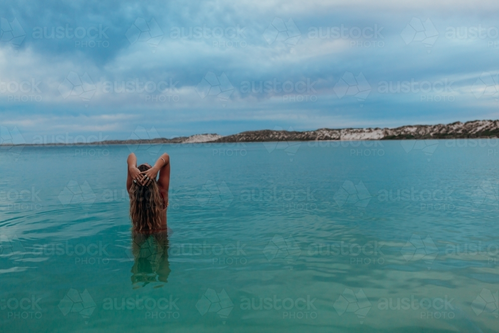 Female in ocean at sunset - Australian Stock Image