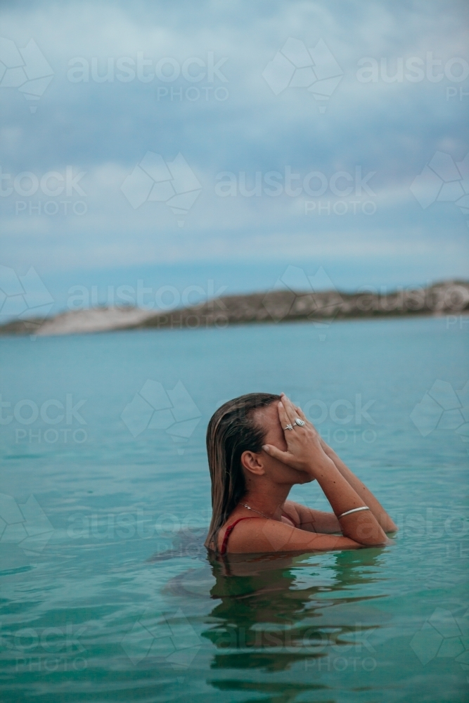 Female in ocean at sunset - Australian Stock Image
