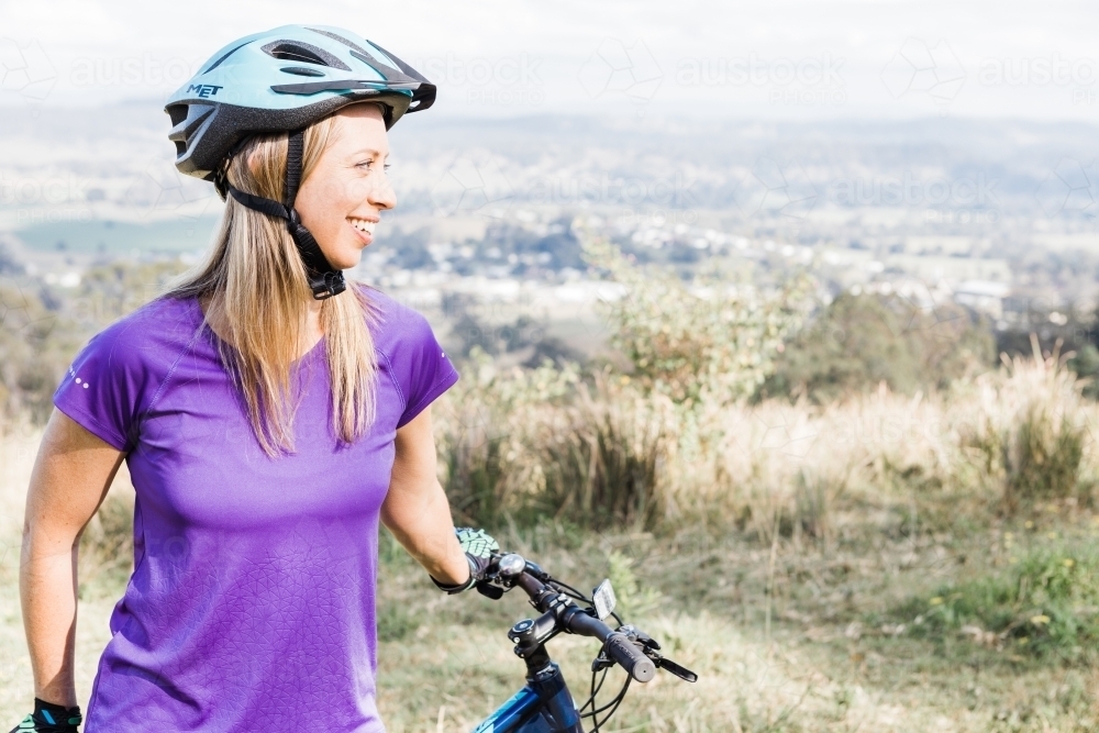 Female mountain bike rider admiring view. - Australian Stock Image