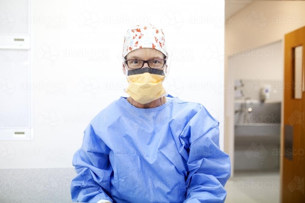 Female nurse dressed in protective clothing ready to perform surgery - Australian Stock Image