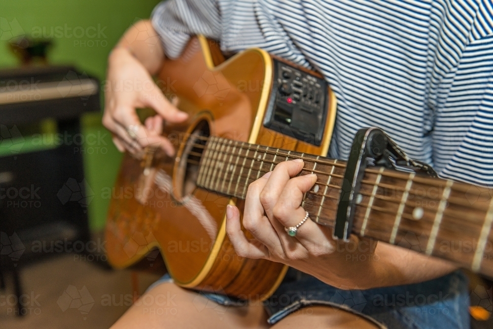 Female playing guitar - Australian Stock Image