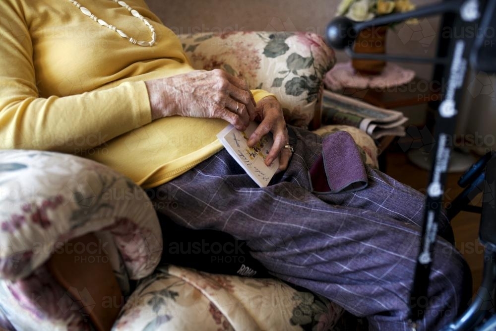 Female retirement village resident sitting in an arm chair - Australian Stock Image