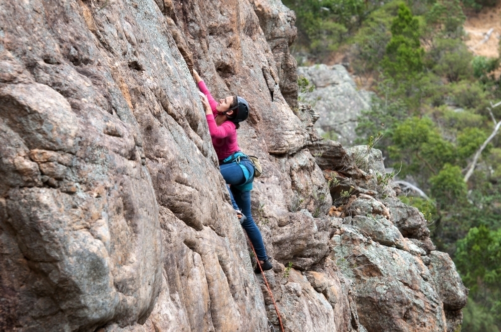 Female rock climbing outdoors - Australian Stock Image