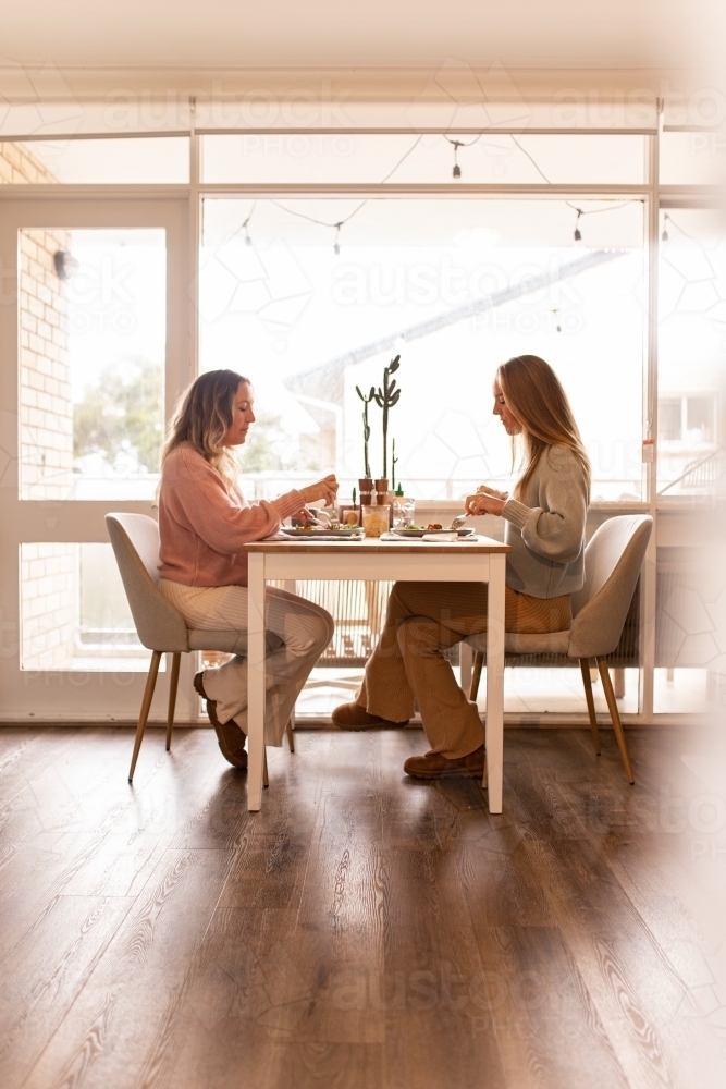 Female same sex couple eating a meal together at home - Australian Stock Image