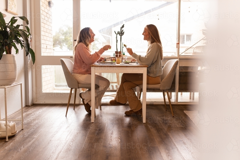 Female same sex couple eating a meal together at home - Australian Stock Image
