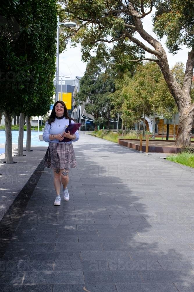 Female Student in Distance Walking Towards Viewer - Australian Stock Image