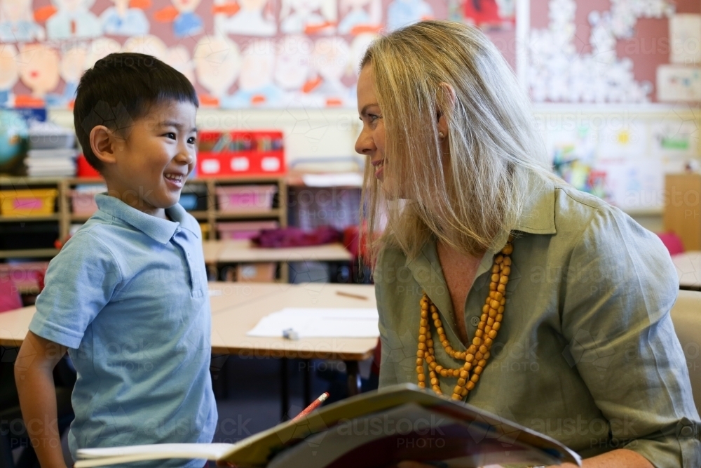 Female teacher speaking to a happy student - Australian Stock Image