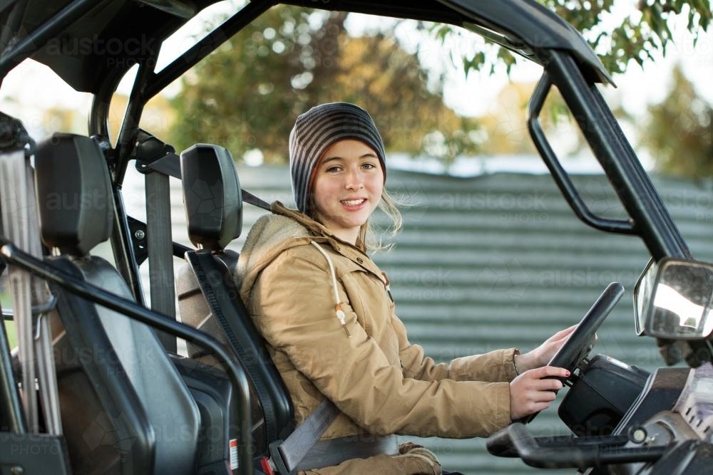 Female teenager driving side-by-side ATV - Australian Stock Image