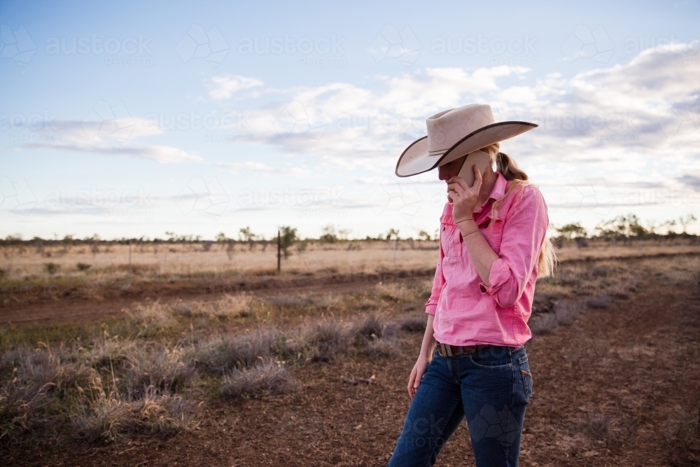 Female teenager holding a phone to her ear on the farm - Australian Stock Image